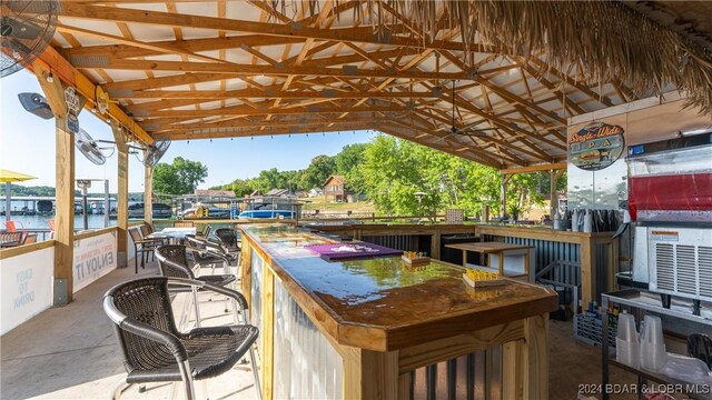 view of patio featuring a water view and a bar