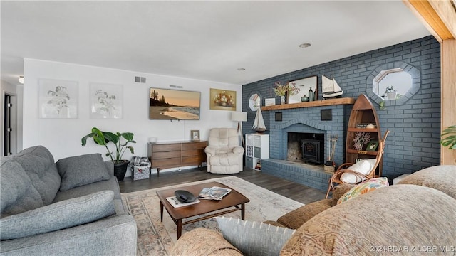 living room featuring wood-type flooring and a brick fireplace