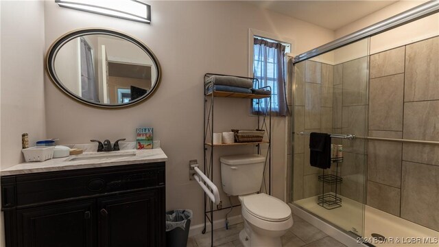 bathroom with vanity, toilet, tile patterned flooring, and walk in shower