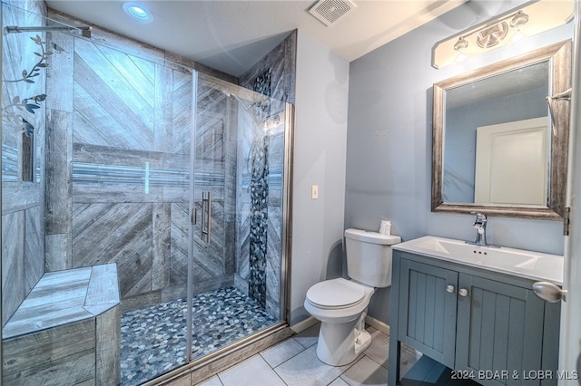 bathroom with vanity, toilet, tile patterned floors, and an enclosed shower