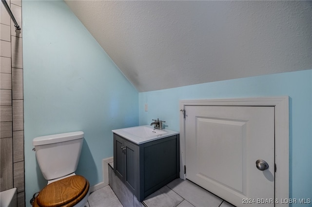 bathroom featuring vanity, a textured ceiling, toilet, lofted ceiling, and tile patterned flooring