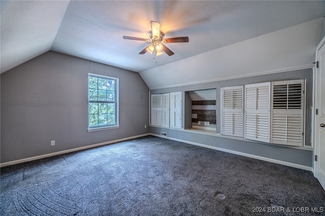 bonus room featuring a textured ceiling, carpet, lofted ceiling, and ceiling fan