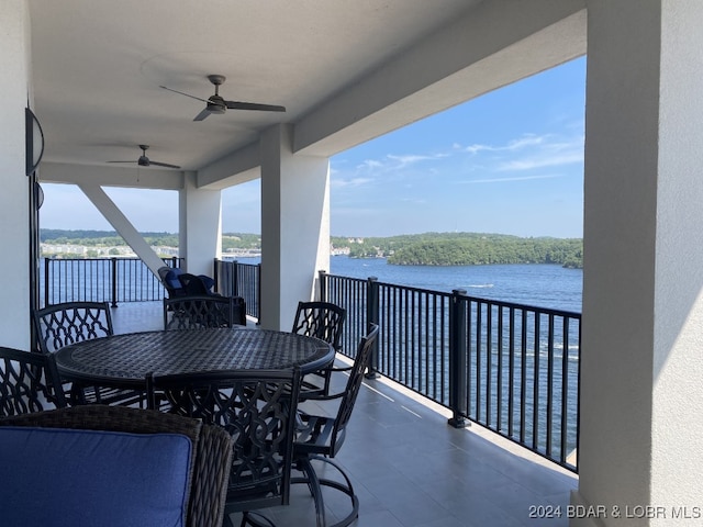 balcony featuring a water view and ceiling fan