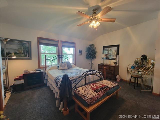 bedroom featuring carpet flooring, ceiling fan, and vaulted ceiling