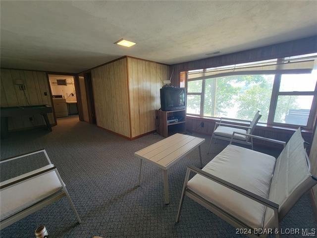 living room featuring carpet floors and wood walls