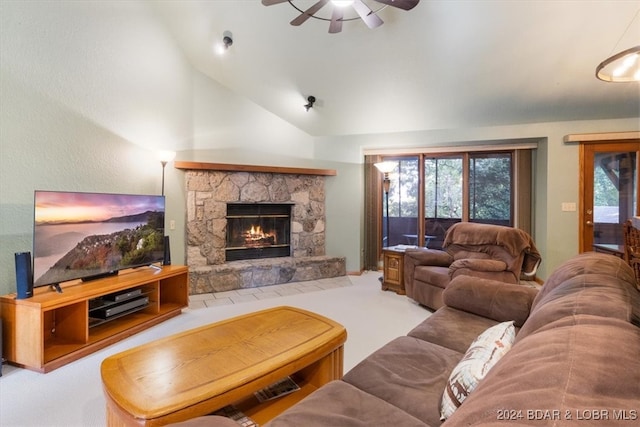 living room featuring ceiling fan, vaulted ceiling, carpet, and a stone fireplace