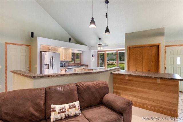 kitchen with ceiling fan, high vaulted ceiling, hanging light fixtures, appliances with stainless steel finishes, and light tile patterned flooring