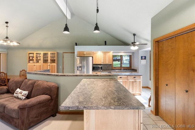 kitchen with light brown cabinets, a kitchen island, appliances with stainless steel finishes, light tile patterned floors, and beamed ceiling