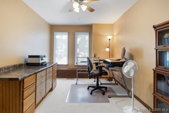 office space with ceiling fan and light carpet