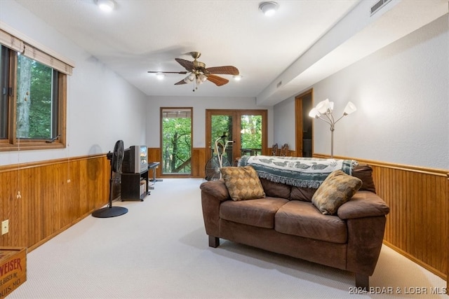 living room featuring light colored carpet, french doors, and ceiling fan