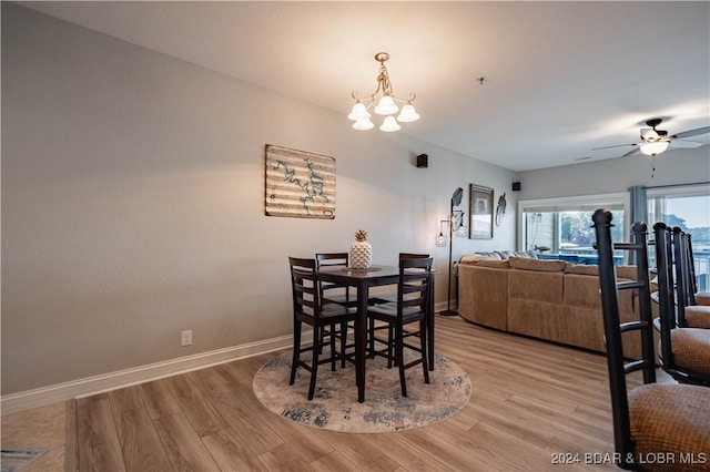 dining area featuring ceiling fan with notable chandelier and light hardwood / wood-style flooring