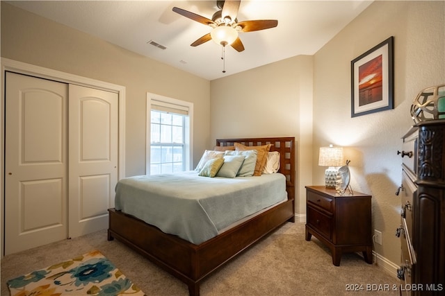 bedroom with a closet, light colored carpet, and ceiling fan