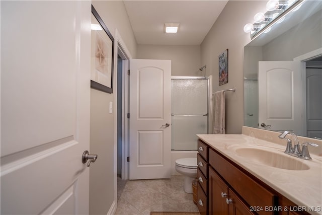 full bathroom with vanity, toilet, combined bath / shower with glass door, and tile patterned flooring