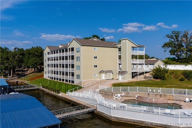 view of property featuring a water view and a fenced in pool