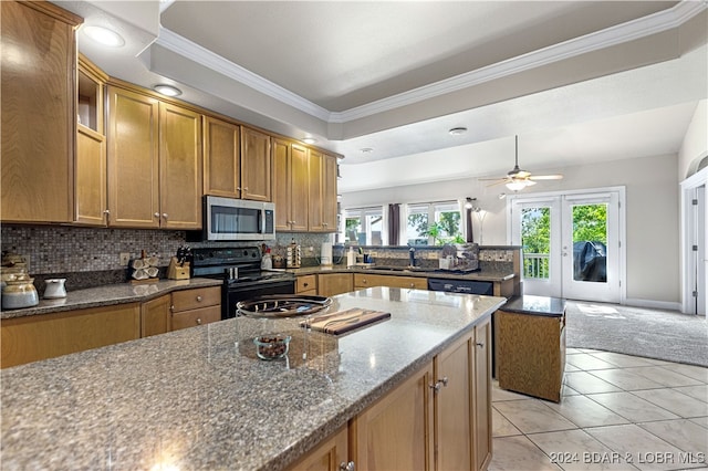 kitchen with dark stone counters, light tile patterned floors, decorative backsplash, black electric range oven, and ceiling fan