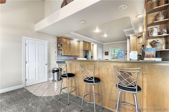 kitchen with light tile patterned floors, decorative backsplash, ornamental molding, stainless steel refrigerator with ice dispenser, and open shelves