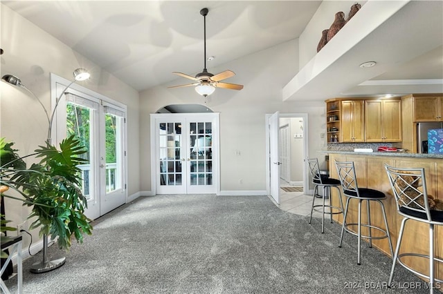 kitchen with french doors, stainless steel refrigerator with ice dispenser, open shelves, light colored carpet, and a kitchen breakfast bar