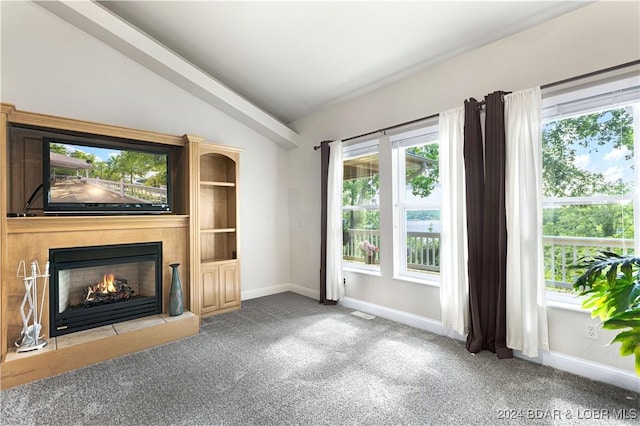 unfurnished living room with lofted ceiling, carpet flooring, a lit fireplace, and baseboards