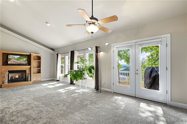 unfurnished living room with carpet floors, french doors, ceiling fan, and a healthy amount of sunlight