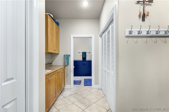 laundry area with light tile patterned floors