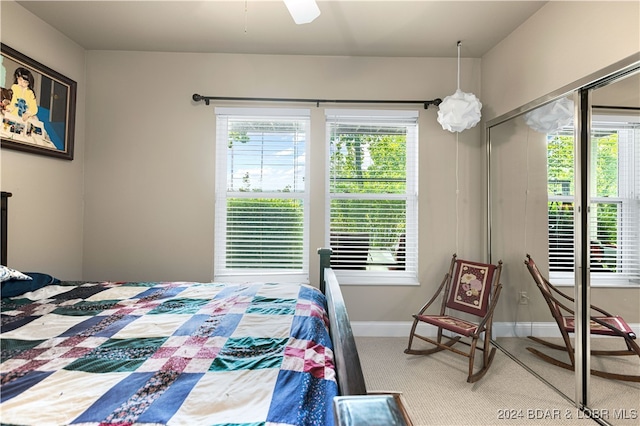 carpeted bedroom featuring multiple windows and ceiling fan