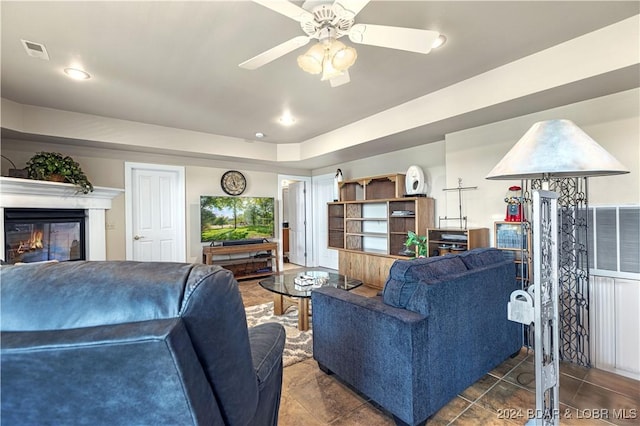 living area with a glass covered fireplace, visible vents, recessed lighting, and tile patterned floors