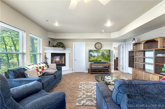 tiled living room featuring visible vents and a glass covered fireplace