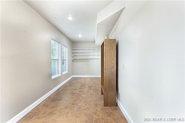 hall featuring recessed lighting and baseboards