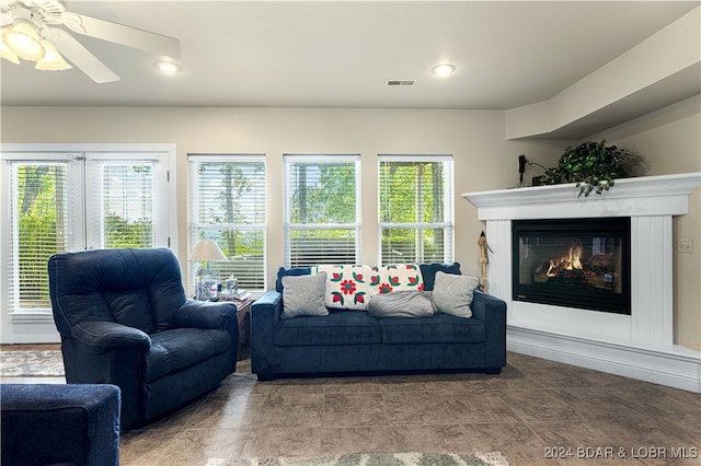 tiled living room with a wealth of natural light and ceiling fan