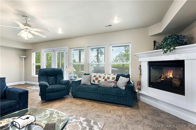 living room with light tile patterned flooring, a wealth of natural light, and ceiling fan