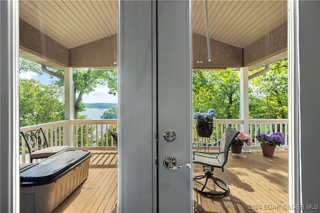 exterior space featuring lofted ceiling, wood-type flooring, and a healthy amount of sunlight