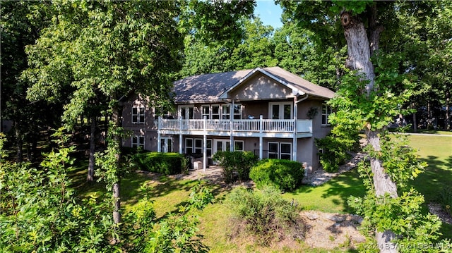 back of property featuring a yard and a balcony