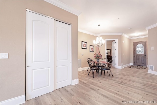 dining area with ornamental molding, a chandelier, and light hardwood / wood-style flooring