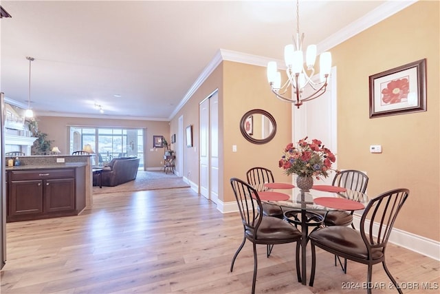 dining room with a notable chandelier, light hardwood / wood-style floors, and ornamental molding