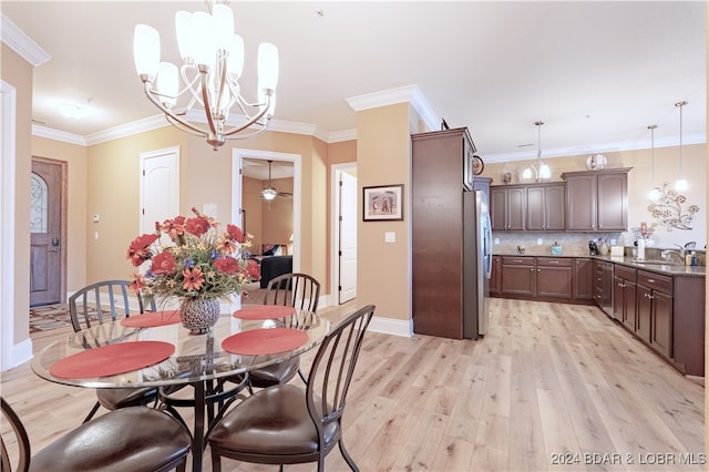 dining area featuring sink, light wood-type flooring, ceiling fan with notable chandelier, and ornamental molding