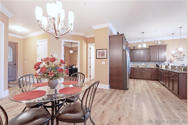 dining room with ornamental molding, sink, and light wood-type flooring