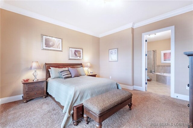 bedroom with ornamental molding, ensuite bath, and light carpet