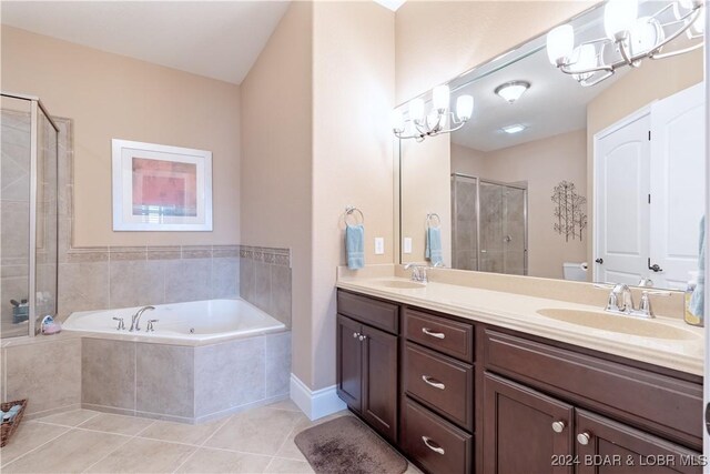 bathroom featuring tile patterned flooring, double sink vanity, plus walk in shower, and an inviting chandelier