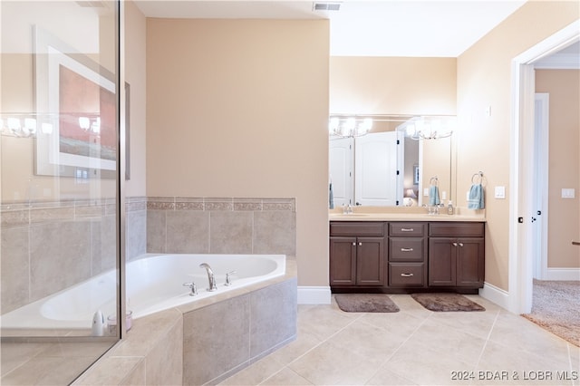 bathroom with tiled bath, dual vanity, and tile patterned floors