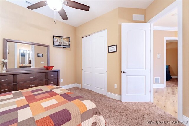 unfurnished bedroom featuring ceiling fan, light carpet, and a closet