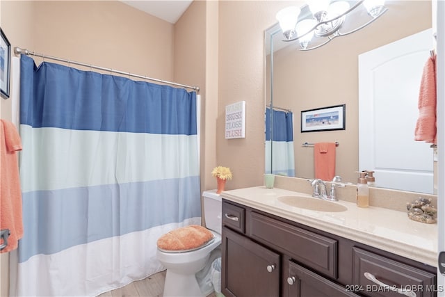 bathroom with toilet, vanity, and a chandelier