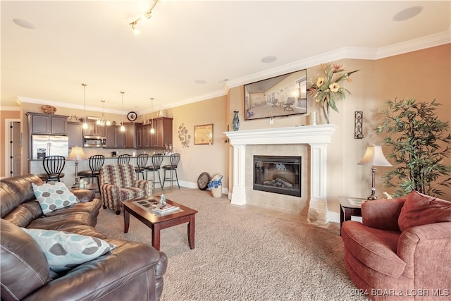 living room with light carpet, rail lighting, crown molding, and a tile fireplace