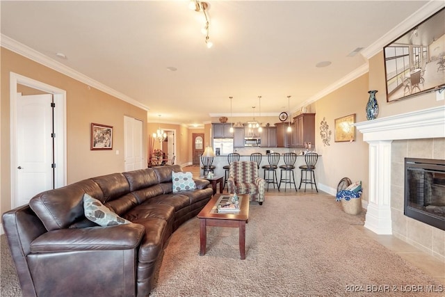 carpeted living room with a tile fireplace, crown molding, and a notable chandelier