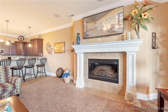 living room featuring a tiled fireplace and crown molding