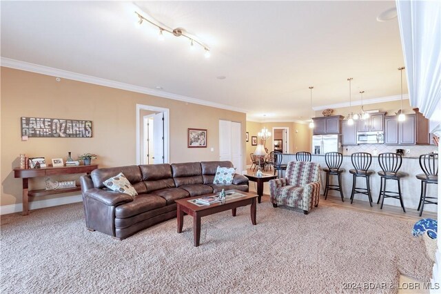 living room with rail lighting, light carpet, plenty of natural light, and ornamental molding