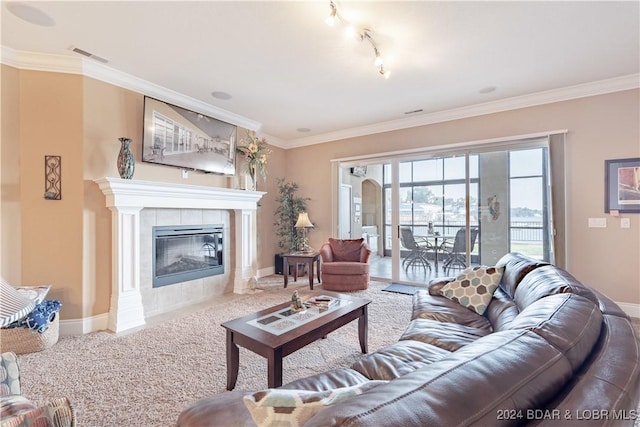 carpeted living room with track lighting, ornamental molding, and a tile fireplace