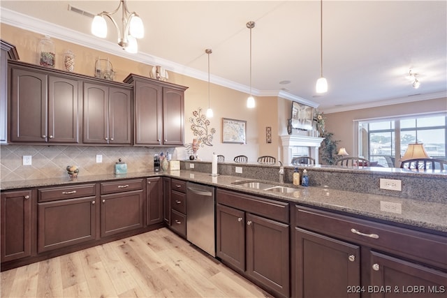 kitchen featuring sink, dark stone countertops, light hardwood / wood-style floors, stainless steel dishwasher, and hanging light fixtures