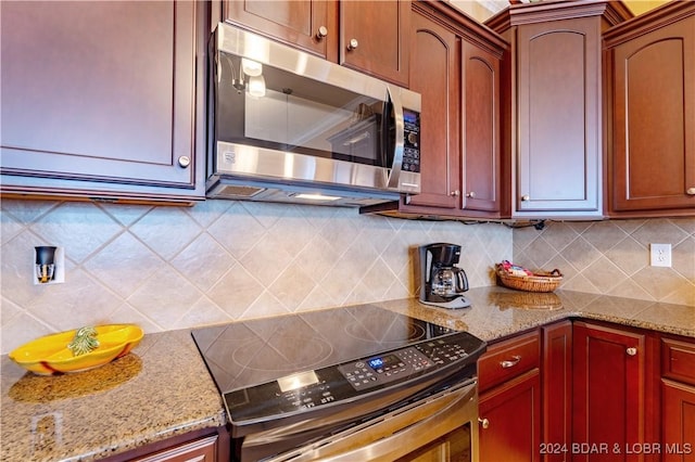 kitchen featuring appliances with stainless steel finishes, light stone counters, and backsplash