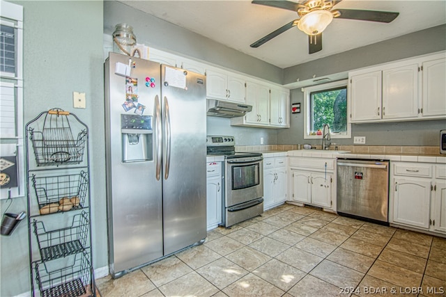 kitchen with sink, white cabinetry, stainless steel appliances, and light tile patterned floors