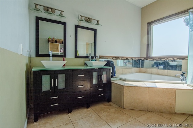 bathroom with tile patterned floors, tiled bath, and vanity